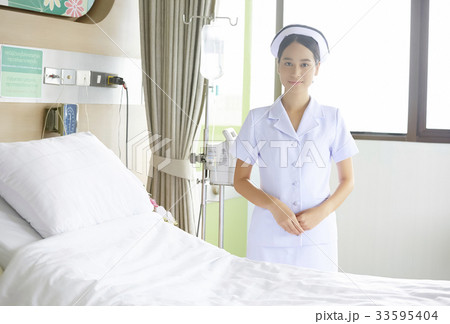 a nurse is standing by the bed in clinic a nurse is standing by the bed in clinic 33595404