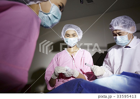 three doctors are working in operating room 33595413