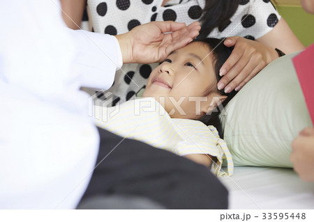 girl is lying and smiling with her mother and doctor 33595448
