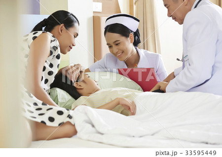 doctor and nurse are talking to a little girl on hospital bed 33595449