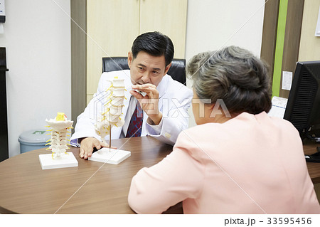 doctor is explaining to senior patient in clinic 33595456