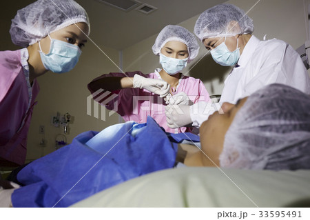 A group of doctor and nurses is doing surgery operation 33595491
