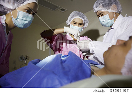 A photo of doctor and nurses doing surgery operation 33595497