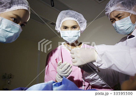 A photo of doctor and nurses doing the surgery operation in room 33595500