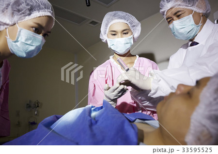 The picture of doctor preparing to injection in a surgery room 33595525
