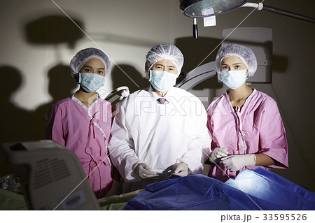 The portrait of doctor and two nurses standing in the operation room 33595526