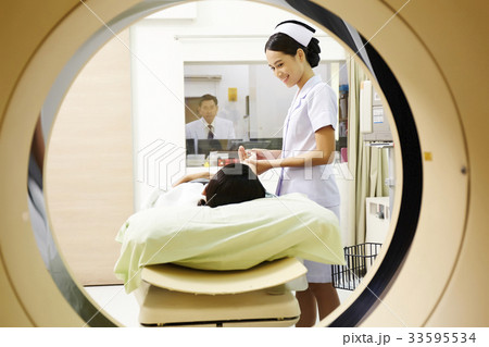 The picture of a nurse preparing to put patient into mri machine The picture of a nurse preparing to put patient into mri machine 33595534