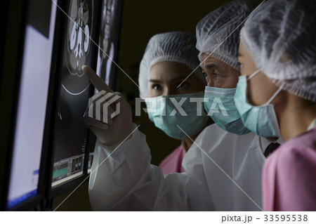 The picture of doctor pointing at mri for two nurses The picture of doctor pointing at mri for two nurses 33595538