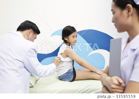 A doctor is doing the examination for a kid by stethoscopes in clinic. A doctor is doing the examination for a kid by stethoscopes in clinic. 33595559