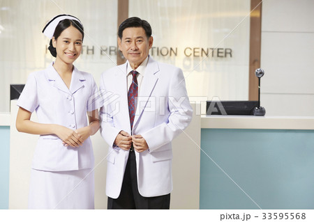 A photo of a nurse and a doctor standing at a reception in hospital. A photo of a nurse and a doctor standing at a reception in hospital. 33595568