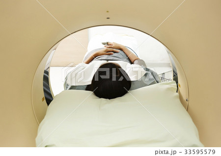 A photo of an Asian young patient going through CT. 33595579