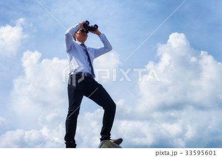 Look. The handsome man is looking at binoculars to the target. Look. The handsome man is looking at binoculars to the target. 33595601