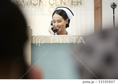 a picture of a nurse answering the telephone in the hospital 33595607