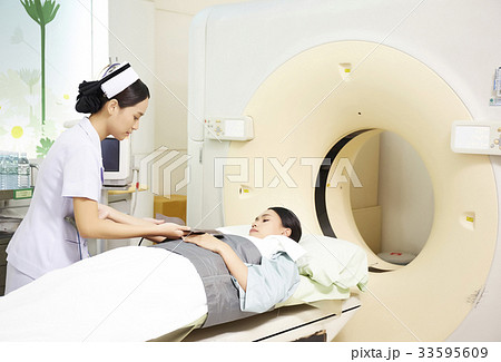 Nurse is preparing for female patient going through CT 33595609