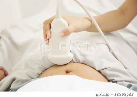 a picture of a nurse holding a scanner and checking her patient 33595632