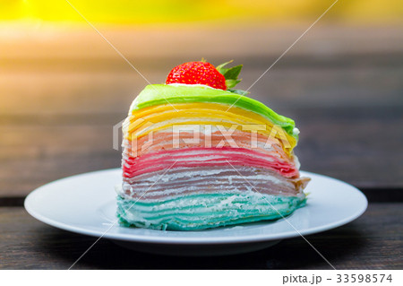 Colorful layer of rainbow crepe cake poured toppin 33598574