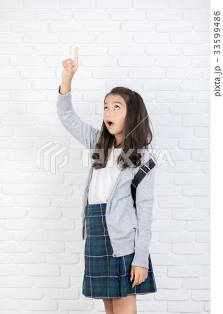 Portrait of a smiling girl pointing finger up at copyspace 33599486
