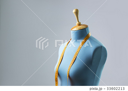 Blue tailor dummy with measuring tape alongside Blue tailor dummy with measuring tape alongside 33602213