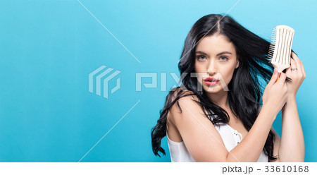 Beautiful woman holding a hairbrush Beautiful woman holding a hairbrush 33610168