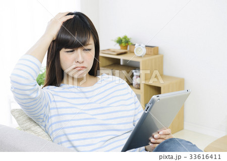 ソファでタブレットをする若い女性 ソファでタブレットをする若い女性 33616411