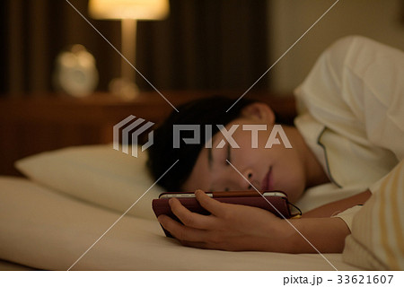 ベッドでスマホを見る女性 33621607