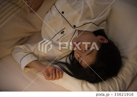 布団で眠る若い女性 33621916