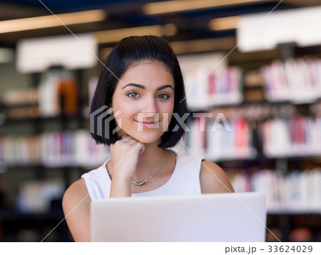 Happy female student at the library 33624029