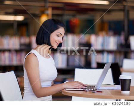 Happy female student at the library Happy female student at the library 33624186