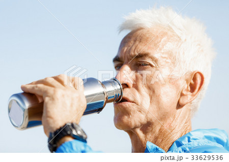 Man drinking from a sports bottle 33629536