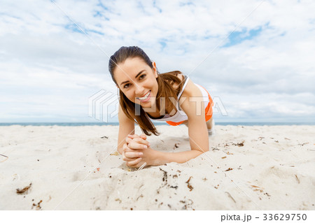 Young woman training on beach outside Young woman training on beach outside 33629750