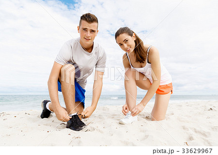 Runners lace their shoes and prepare to jogging 33629967