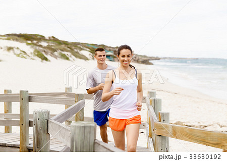 Runners. Young couple running on beach Runners. Young couple running on beach 33630192