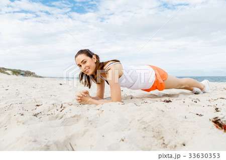 Young woman training on beach outside 33630353