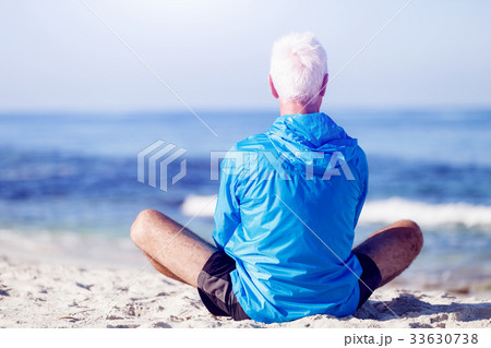 Man in sports wear sitting at the beach 33630738