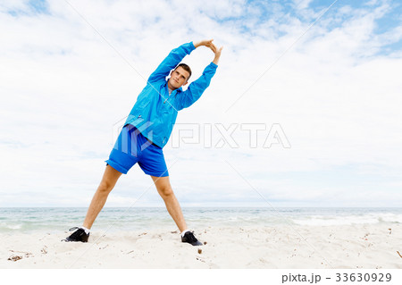 Man training on beach outside 33630929