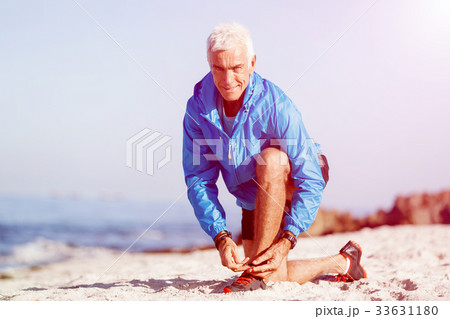 Runner laces his shoes and prepares to jogging 33631180