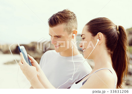Couple of runners with mobile smart phones outdoors Couple of runners with mobile smart phones outdoors 33631206