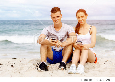 Couple of runners with mobile smart phones outdoors 33631261
