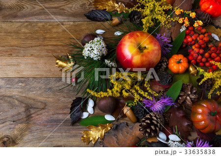 Fall decoration with flowers and apple on wood 33635838