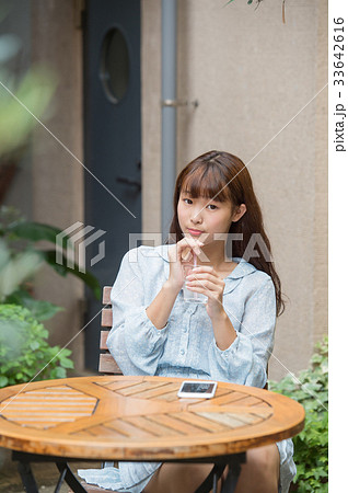 女子高生 高校生 Jk 大学生 待ち合わせ 一人 かわいい きれい 美しい ロング カフェの写真素材