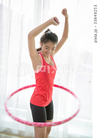 Asian women  playing hula hoop at home. 33649253