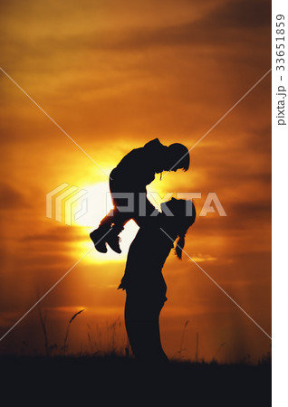 Silhouettes of mother and son playing at sunset Silhouettes of mother and son playing at sunset 33651859