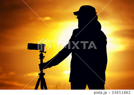 Female photographer with camera during sunset Female photographer with camera during sunset 33651862