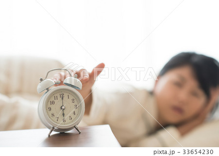 目覚まし時計を止める女性 33654230