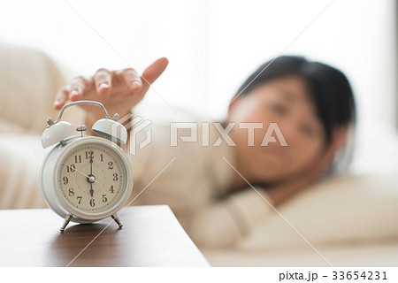 目覚まし時計を止める女性 33654231