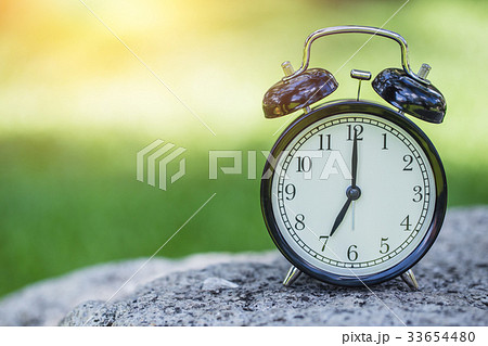 clock in the green nature time at 7 o'clock. 33654480