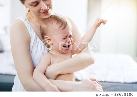 Woman with crying baby Woman with crying baby 33658180