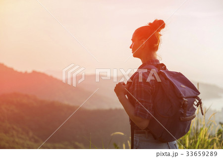 Hipster young girl with backpack enjoying sunset 33659289
