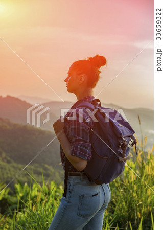 Hipster young girl with backpack enjoying sunset  33659322