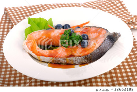 salmon steak with vegetables and fruit. 33663198